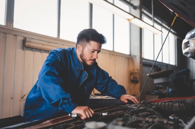 Motor arızası arayan dalgın bir oto tamircisi. Araba tamiri kavramı