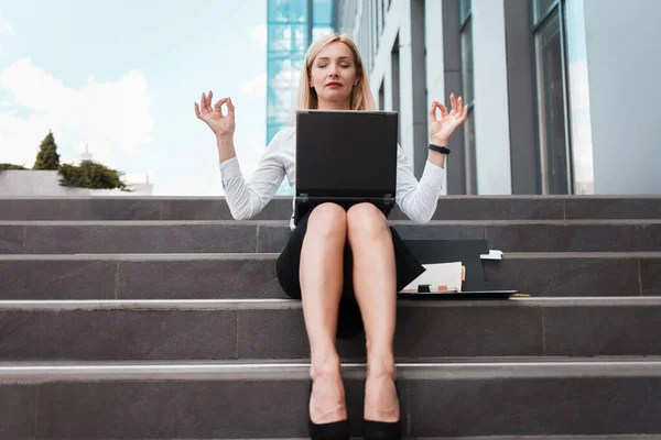 Female office worker resting from work with meditation. Overwork concept