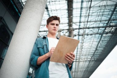 Dosyası olan yakışıklı adam belgeleri okuyor.