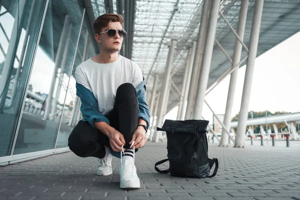 Casual Jovem Cara Amarra Seus Cadarços Perto Terminal Aeroporto — Fotografia de Stock