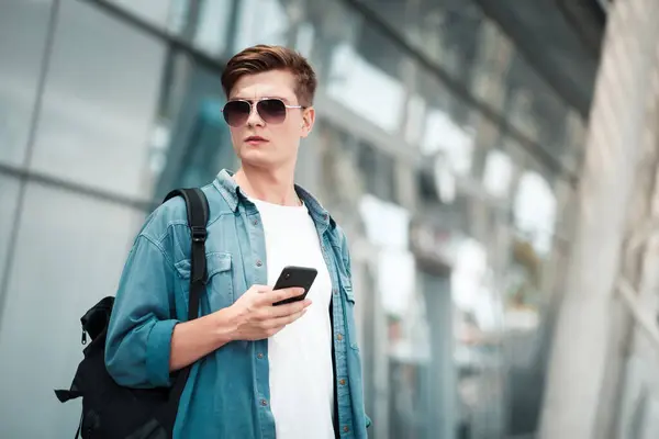 Młody Mężczyzna Okularach Przeciwsłonecznych Smartfonem Rękach — Zdjęcie stockowe