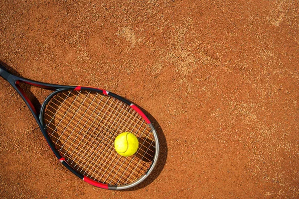 Tenis raketi ve top sahada.