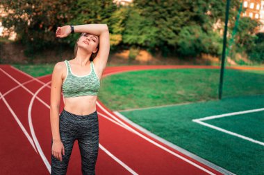 Yorgun koşucu eliyle yüzünü siliyor.