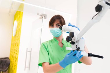 Diş hekimi diş mikroskobu kullanıyor.