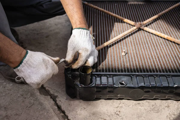 Bir oto tamircisinin kirli elleri çalışıyor.