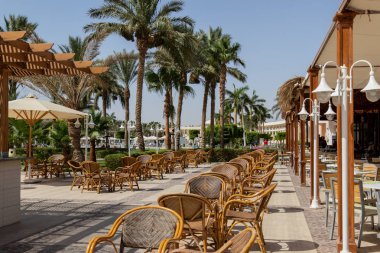 Hurghada, Makadi Bay, Mısır ,12 Haziran 2018, öğlen restoranın yaz terasında rattan mobilya palmiye ağaçlarının arka planda insanlar olmadan