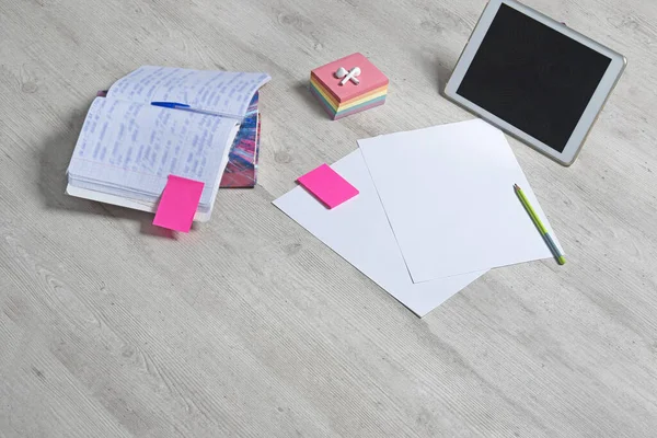 Sınavlar için hazırlık. Bir kitap, bir not defteri ve kulaklıklı bir tablet.