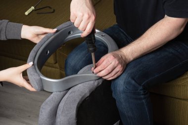 Takım çalışması montaj koltuğunda. Kız, erkeğin sandalyesini tamir etmesine yardım eder.