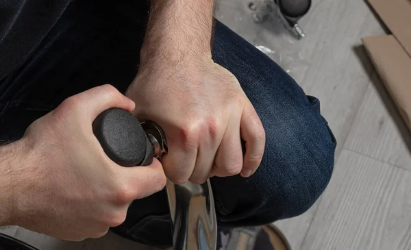 Adam ofis sandalyesini içeride monte ediyor. Mobilya konsepti ve alımı