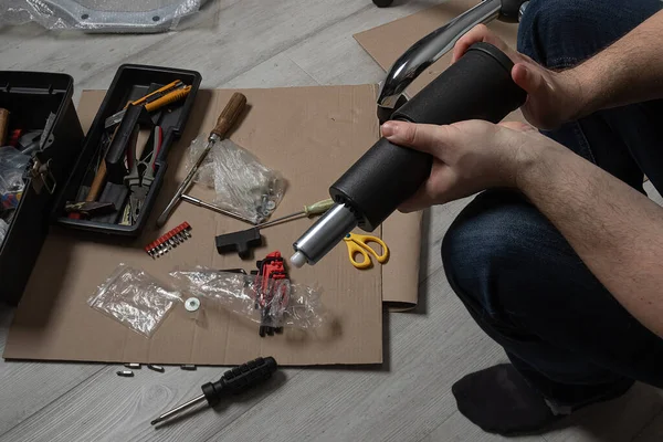 open box with tool and spare part in  hands of man. The concept of assembly and repair at home.