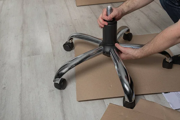 man assembling  office chair indoors. Assembly concept and purchase of furniture