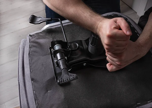 Adam ofis sandalyesini içeride monte ediyor. Mobilya konsepti ve alımı