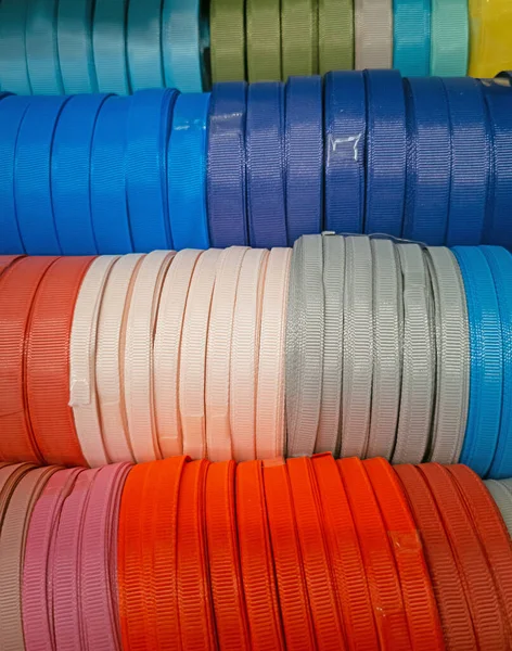 Rafta desenli ipek kurdeleler var. Ev yapımı konsept. Dikiş dükkanında sıra sıra dizilmiş renkli kurdeleler.