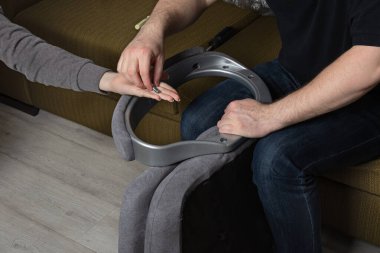 Takım çalışması montaj koltuğunda. Ofis sandalyesini içeride monte eden adam. Kız, erkeğin sandalyesini tamir etmesine yardım eder.