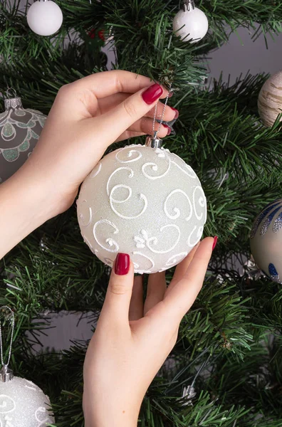 Noel beyaz topu küçük bir kızın elinde. Yeni yıl kutlamaları. Hazırlık konsepti. Dikey yönelim