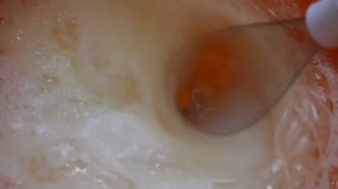 Yakın çekim Çırpma yumurta sarısı ile şeker. Yumurta sarısı ve şeker elektrikli Mikser yardımı ile karıştırma.