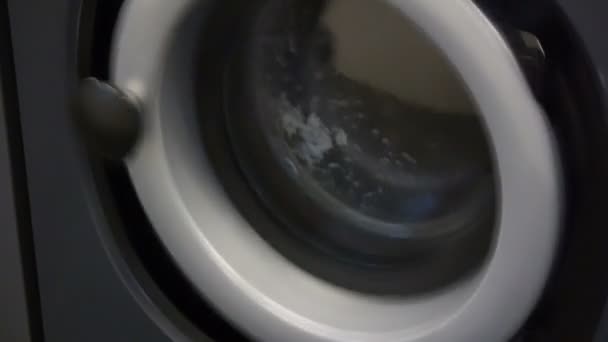 Detail videa samoobslužné prádelny - mince laundrywashing strojů a barevné prádlo. — Stock video