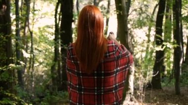 Ormanda yalnız yürüyen kız. Genç kız bir ekose sarılmış.