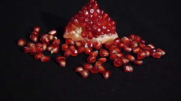 Část čerstvě zhotovit granátové jablko. Čerstvé červené granátové semeno izolované na černém pozadí. — Stock video
