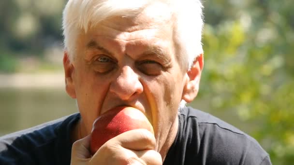 Το πορτρέτο του γέρου που τρώει ένα μήλο. Κοντινό. Άνθρωπος για να φάει ένα μήλο. — Αρχείο Βίντεο