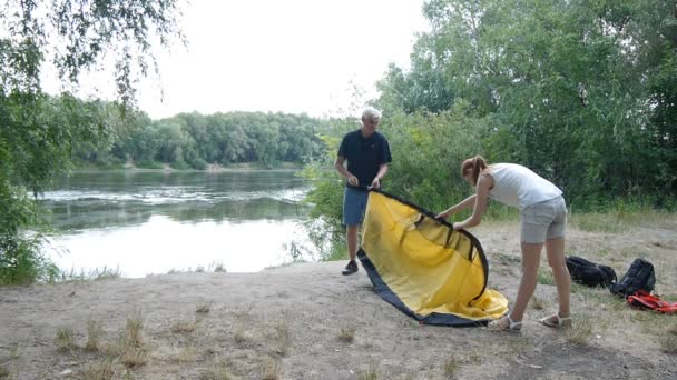 Campers putting up tent, preparing to overnight in wild, green tourism, hiking. Happy travels concept. — Stock Video