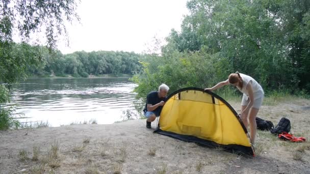 Baba ve kız kampçılar çadır kuruyor. Yeşil turizm, yürüyüş. Mutlu seyahatler kavramı. — Stok video