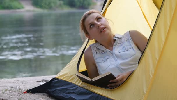 Młoda dziewczyna Hiker czyta książkę w namiotach kempingowych, marzenia i rozgląda. Szczęśliwy uśmiechnięty. Koncepcja zdrowego aktywnego stylu życia. — Wideo stockowe