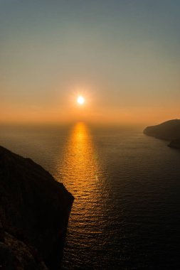 kayalar ve batan güneşin deniz manzarası doğal görünümünü