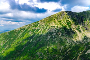 Yeşil ve mavi bulutlu gökyüzü ile büyüleyici doğa dağ manzaralı