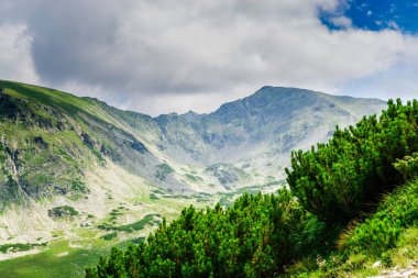 Yeşil ve mavi bulutlu gökyüzü ile büyüleyici doğa dağ manzaralı