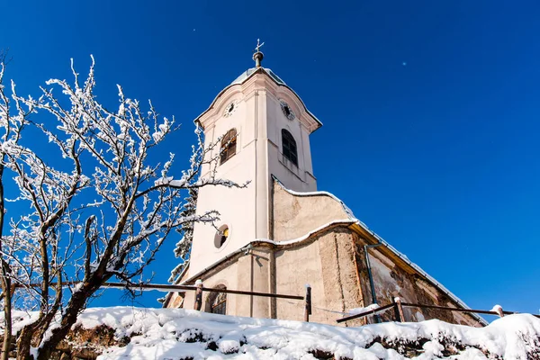 church on hill, snow covered tree branches in winter