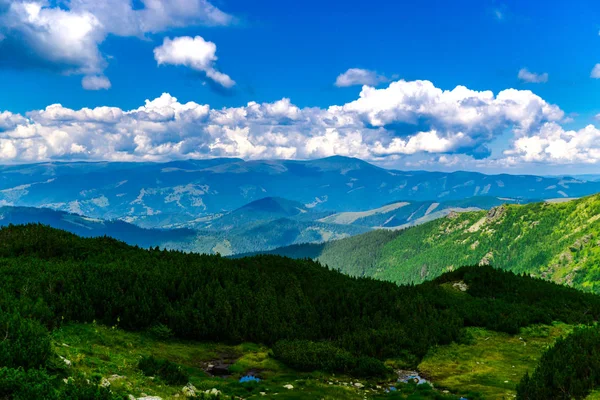 Yeşil ve mavi bulutlu gökyüzü ile büyüleyici doğa dağ manzaralı