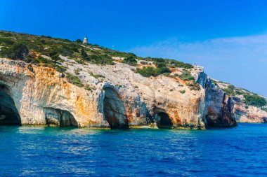 deniz, kayalar ve mavi bulutlu gökyüzü ısmarlayarak
