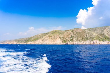 deniz, kayalar ve mavi bulutlu gökyüzü ısmarlayarak