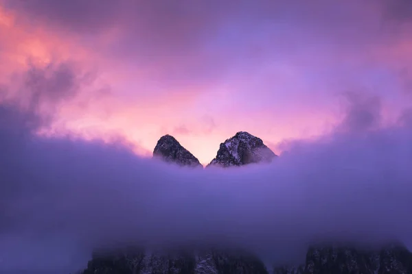 purple sky, hill top covered in clouds