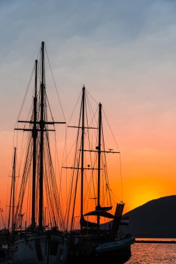 Dramatik gün batımı gökyüzüne karşı gemilerle liman