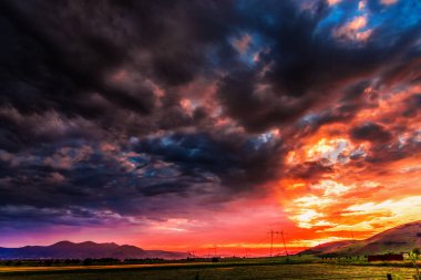 Elektrik kuleleri ve tepeler ile dramatik günbatımı gökyüzü