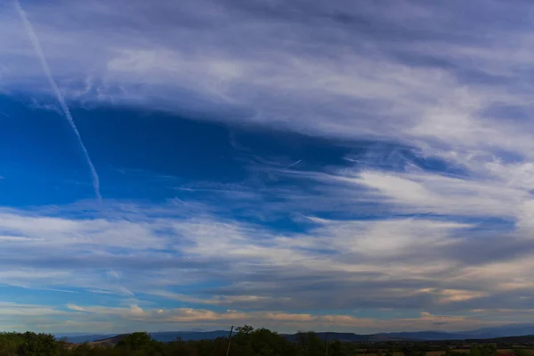 beautiful cloudscape over hills with electrical towers