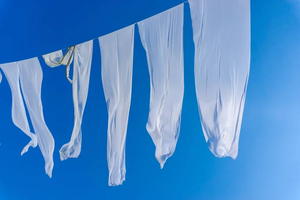 Windy white textile on blue sky background
