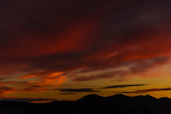 丘の上のオレンジ色の夕焼け空 — ストック写真