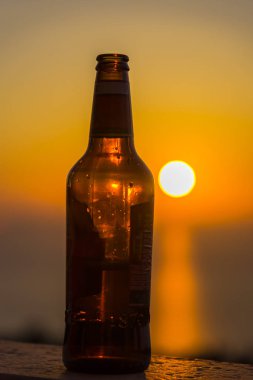 Gün batımı gökyüzüne karşı şişe yakın