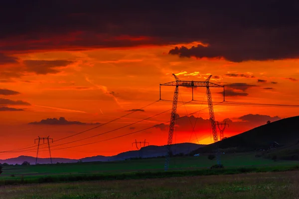 Dramatischer Sonnenuntergang Mit Stromtürmen Und Hügeln — Stockfoto