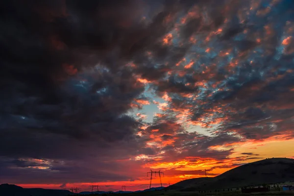 dramatic sunset sky with electric towers and hills