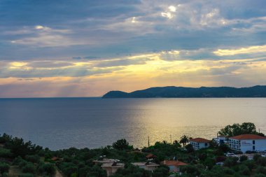 deniz ve binalar yeşil kıyısında günbatımı gökyüzünün doğal görünümü