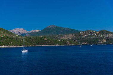 yüzen tekneler ile mavi deniz suyu, arka planda ada 