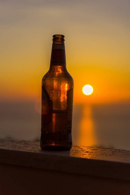 Gün batımı gökyüzüne karşı şişe yakın
