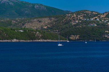 yüzen tekneler ile mavi deniz suyu, arka planda ada 