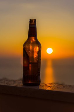 Gün batımı gökyüzüne karşı şişe yakın