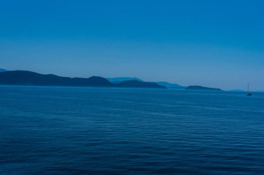 Dağ arka plan ile pürüzsüz oldukça okyanusun büyüleyici görünümü