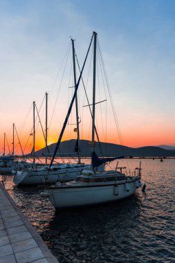 Dramatik gün batımı gökyüzüne karşı gemilerle liman